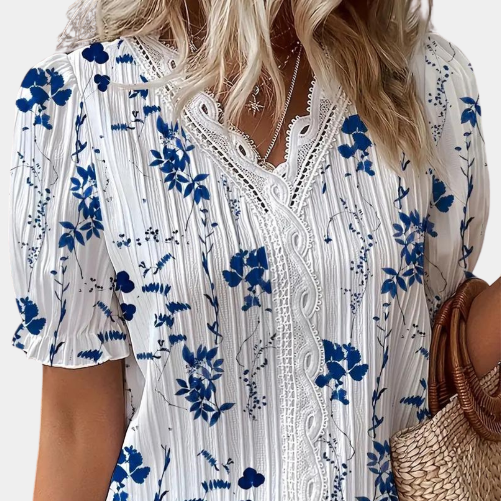 Blomstret damebluse med blondekant i blå, elegant og sommerligt design. Behageligt stof, perfekt til både dag og aften.
