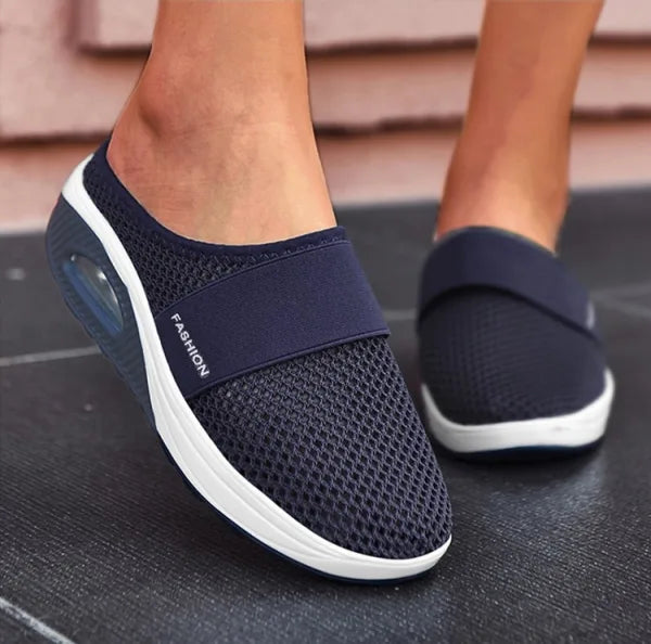 Elegant slip-on damesandaler i sort med komfortabel polstring og tidløst design, perfekt til daglig brug og fest.