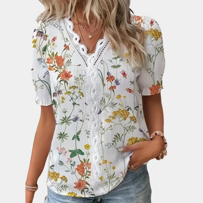 Blomstret damebluse med blondekant i blå, elegant og sommerligt design. Behageligt stof, perfekt til både dag og aften.