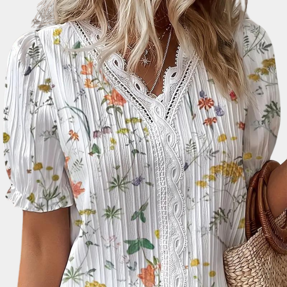 Blomstret damebluse med blondekant i blå, elegant og sommerligt design. Behageligt stof, perfekt til både dag og aften.