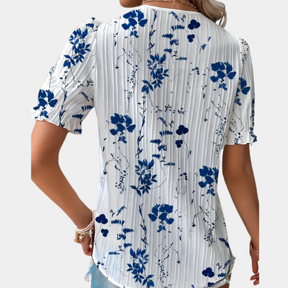 Blomstret damebluse med blondekant i blå, elegant og sommerligt design. Behageligt stof, perfekt til både dag og aften.