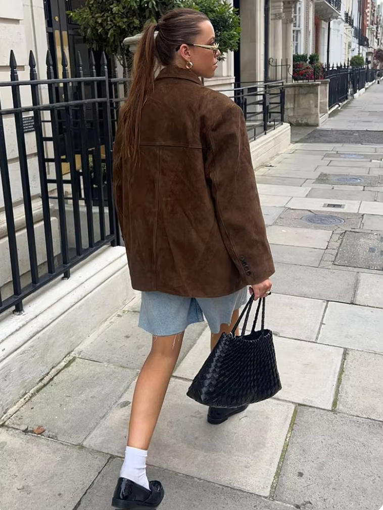 "Brun ruskindsjakke til kvinder med klassisk design, knaplukning og praktiske lommer, perfekt til overgangssæsonen."