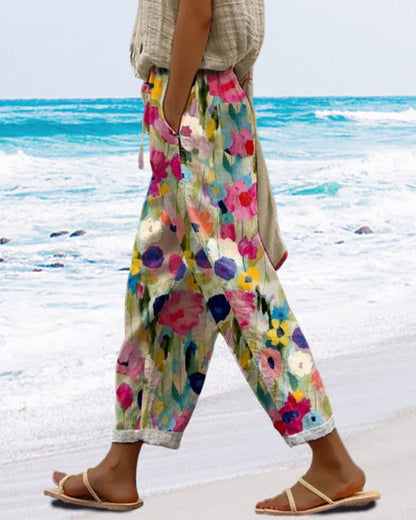 Dame bukser med løs pasform, blomsterprint, brede ben og elastisk talje. Farverig og feminin stil, perfekt til hverdagsbrug.