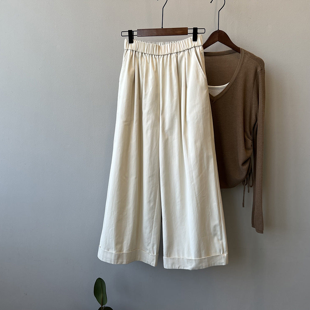 "Dame culotte-bukser med vide ben, elastisk talje og elegant folder, set forfra i lys beige farve."