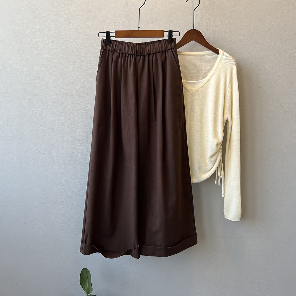 "Dame culotte-bukser med vide ben, elastisk talje og elegant folder, set forfra i lys beige farve."