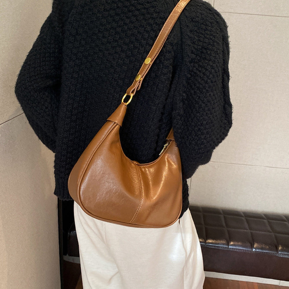 "Elegant crossbodytaske i vegansk læder med justerbar rem og guldfarvede detaljer, ideel til hverdagsbrug."