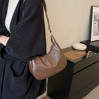 "Elegant crossbodytaske i vegansk læder med justerbar rem og guldfarvede detaljer, ideel til hverdagsbrug."