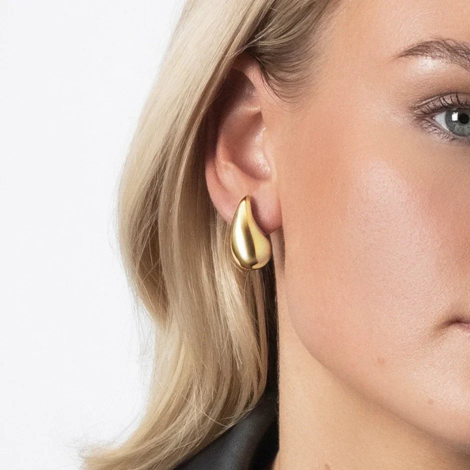 "Elegant dråbeformede øreringe i sølv og guld, skinnende overflade, moderne skulpturelt design til kvinder"