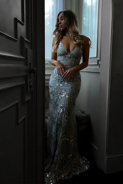 "Elegant gulvlang aftenkjole i gråt pailletstof, tæt pasform, dyb V-udskæring, perfekt til gallafester."