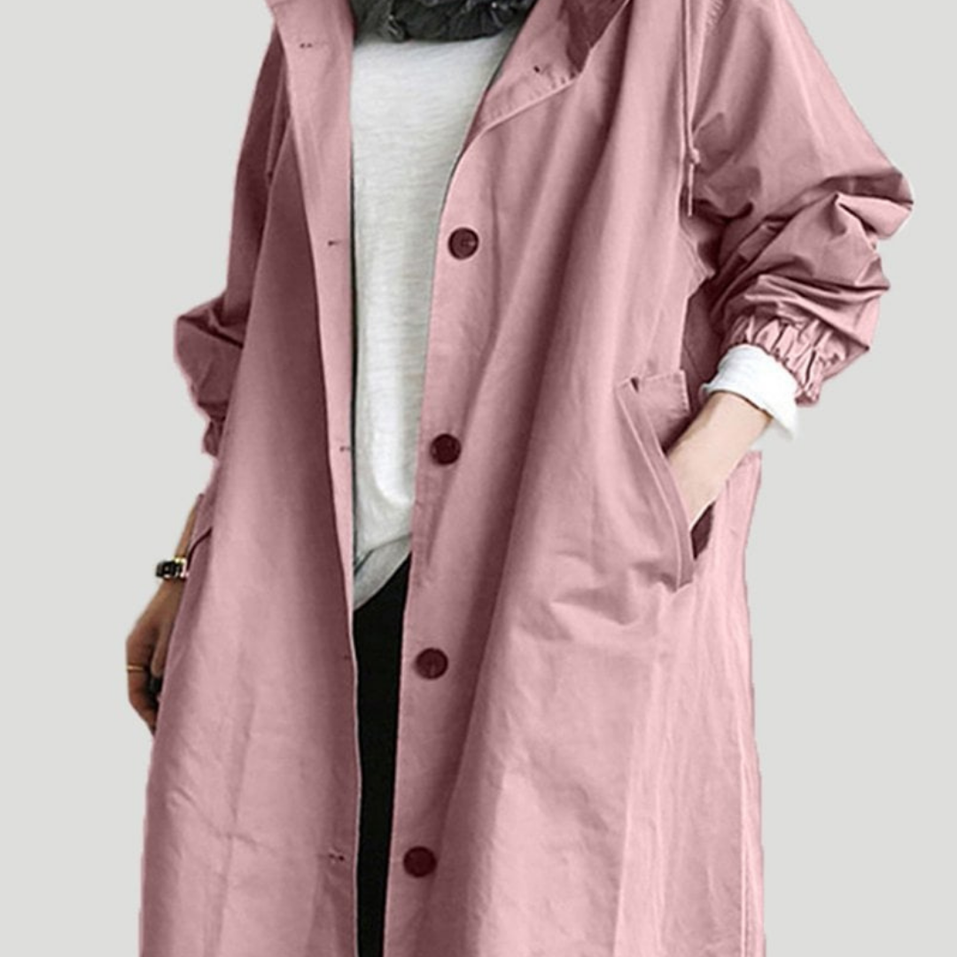 "Elegant vandtæt trenchcoat til kvinder i pastelrosa, lang silhuet, praktiske lommer, perfekt til regnfulde dage."