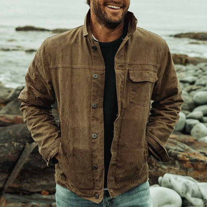 "Herrejakke i robust bomuld, beige med knaplukning og enkel brystlomme, afslappet pasform, velegnet til hverdagsbrug."