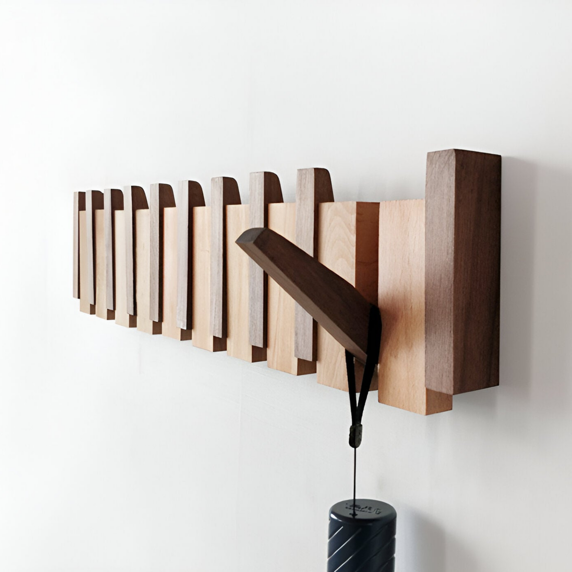 "Knagerække med foldbare magnetkroge, elegant og minimalistisk design i valnød, står mod lys væg, 42x15 cm."