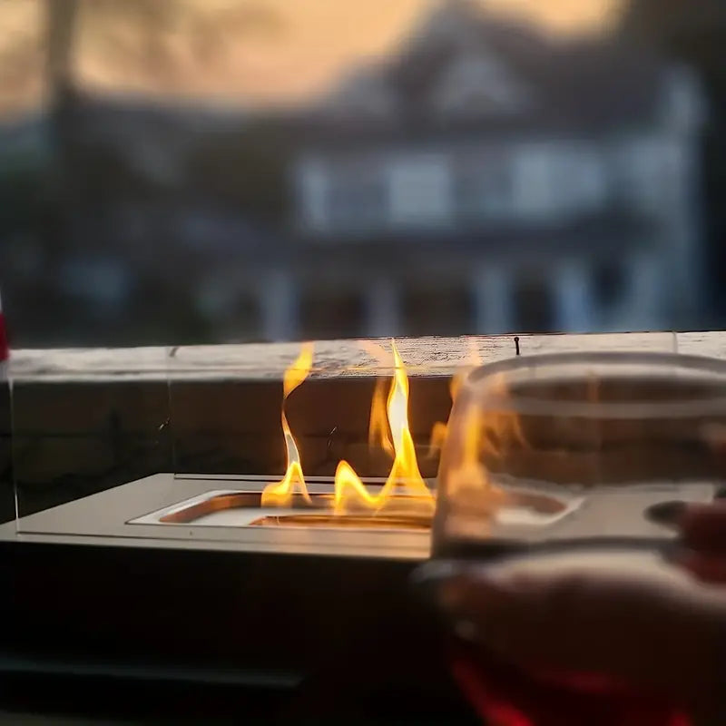 "Luksuriøs udendørs pejs i rustfrit stål med moderne glaspaneler og røgfri flammer for sikker belysning."