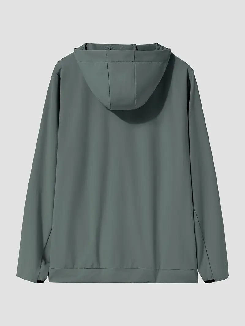 "Mand i åndbar, vindtæt løbejakke med hætte, der viser stilfuldt design og komfort under træning i blæsende vejr."