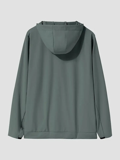 "Mand i åndbar, vindtæt løbejakke med hætte, der viser stilfuldt design og komfort under træning i blæsende vejr."