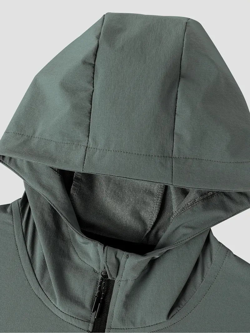 "Mand i åndbar, vindtæt løbejakke med hætte, der viser stilfuldt design og komfort under træning i blæsende vejr."