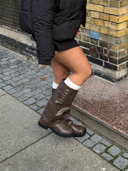 "Mørkebrune støvler under knæet, tre spænder, klassisk design, elegant mørkebrun farve, sofistikeret look"