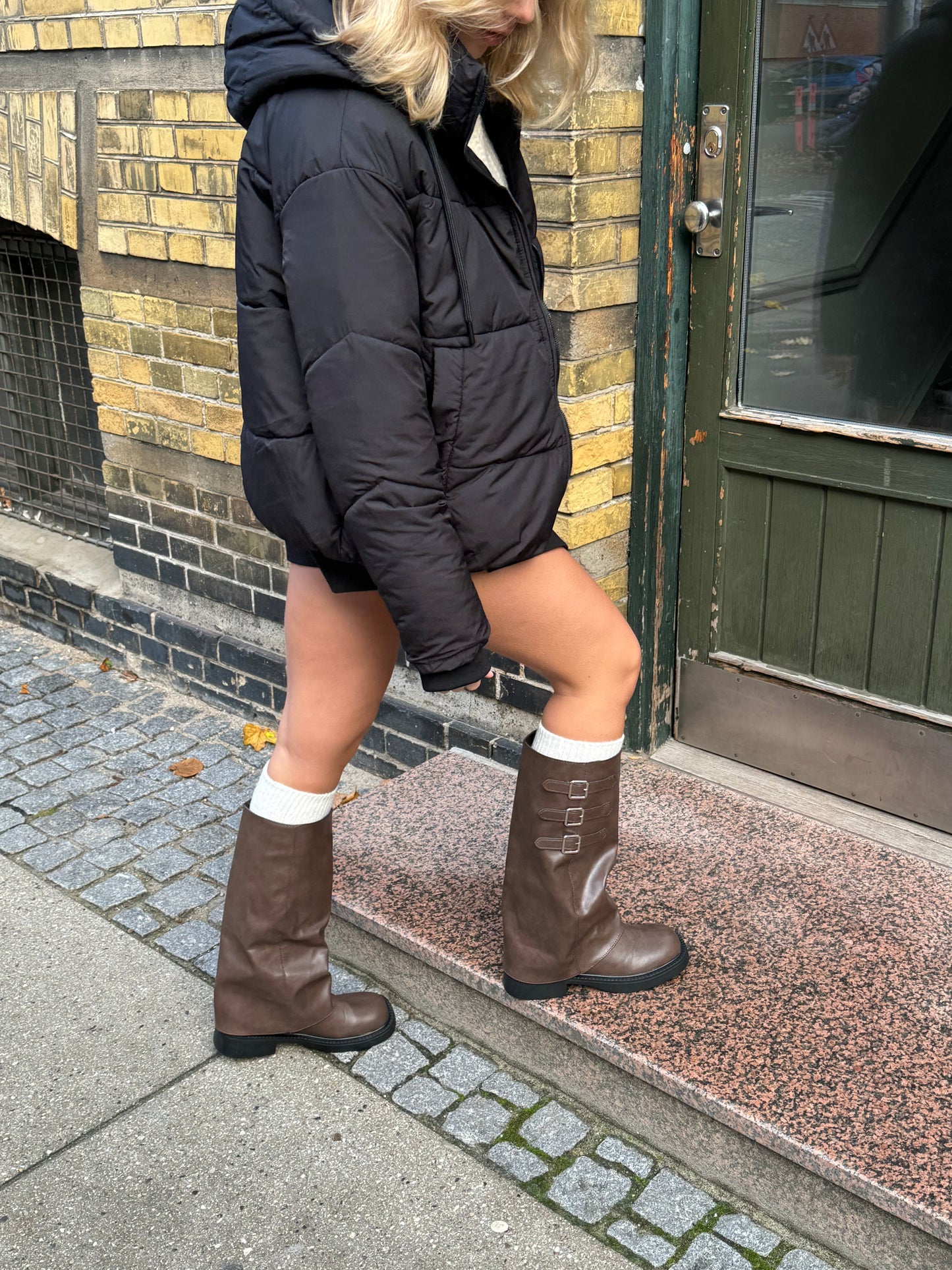 "Mørkebrune støvler under knæet, tre spænder, klassisk design, elegant mørkebrun farve, sofistikeret look"