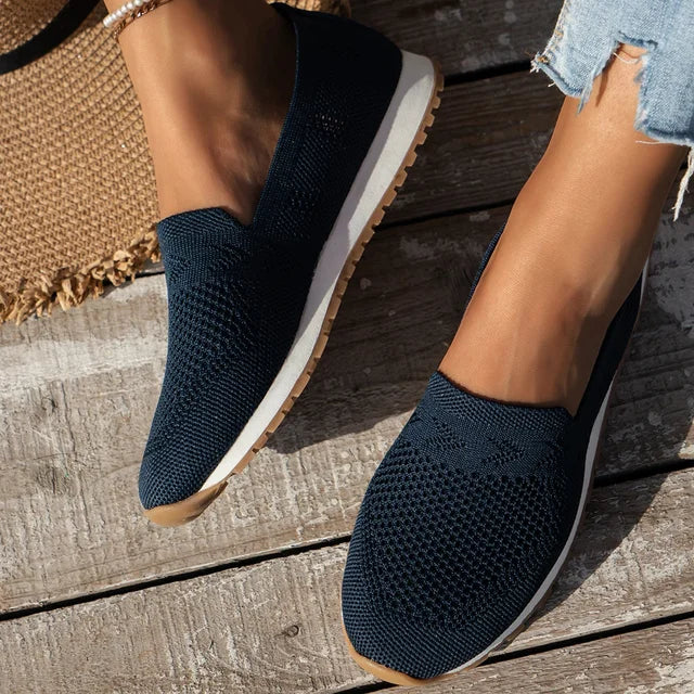 "Ortopædiske dame slip-ons i marineblå med åndbar fodseng, let slip-on design og elegant stil."