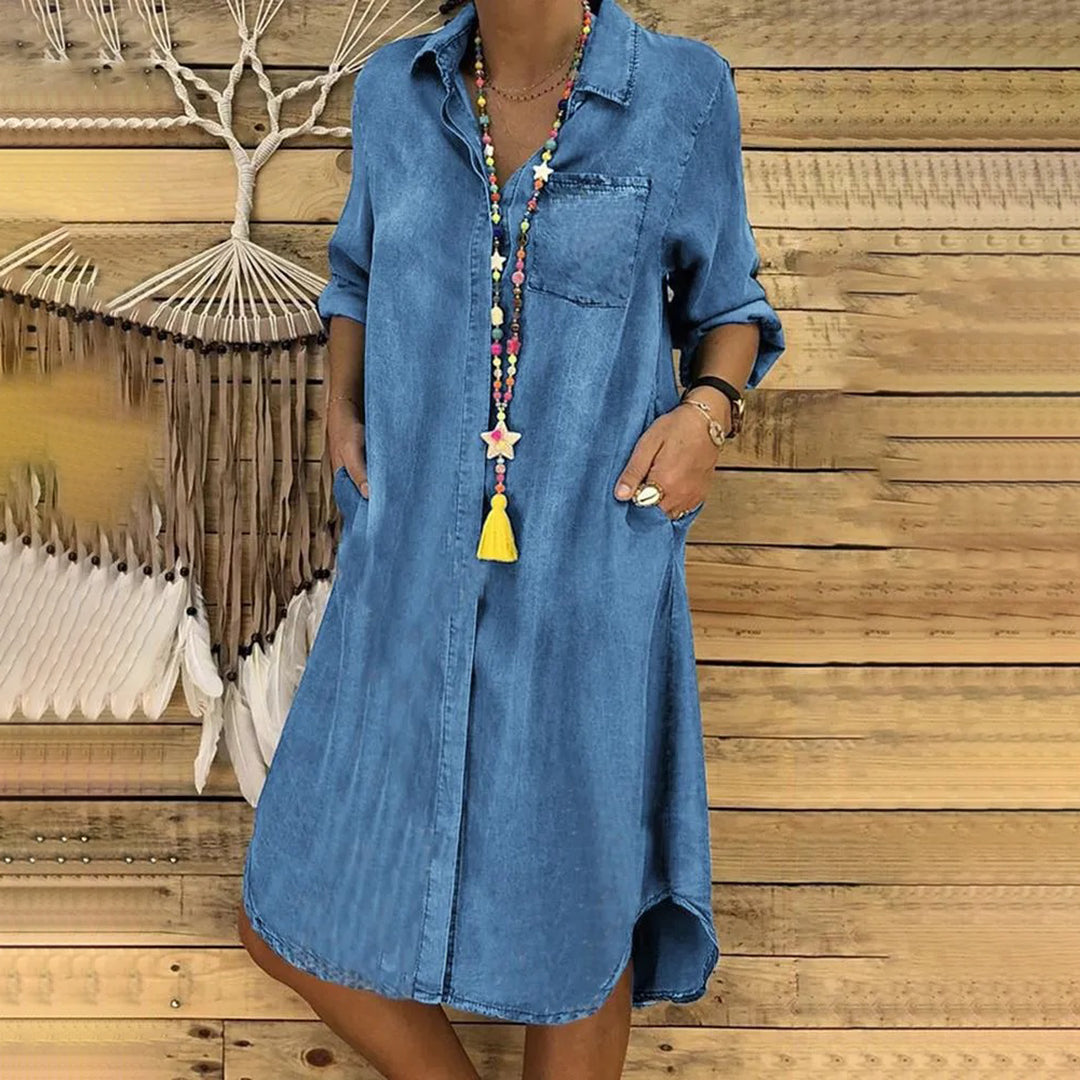 "Stilfuld forårskjole i blå og mørkeblå, elegant snit, ideel til sæsonens skiftende vejr, flaterende og komfortabel."