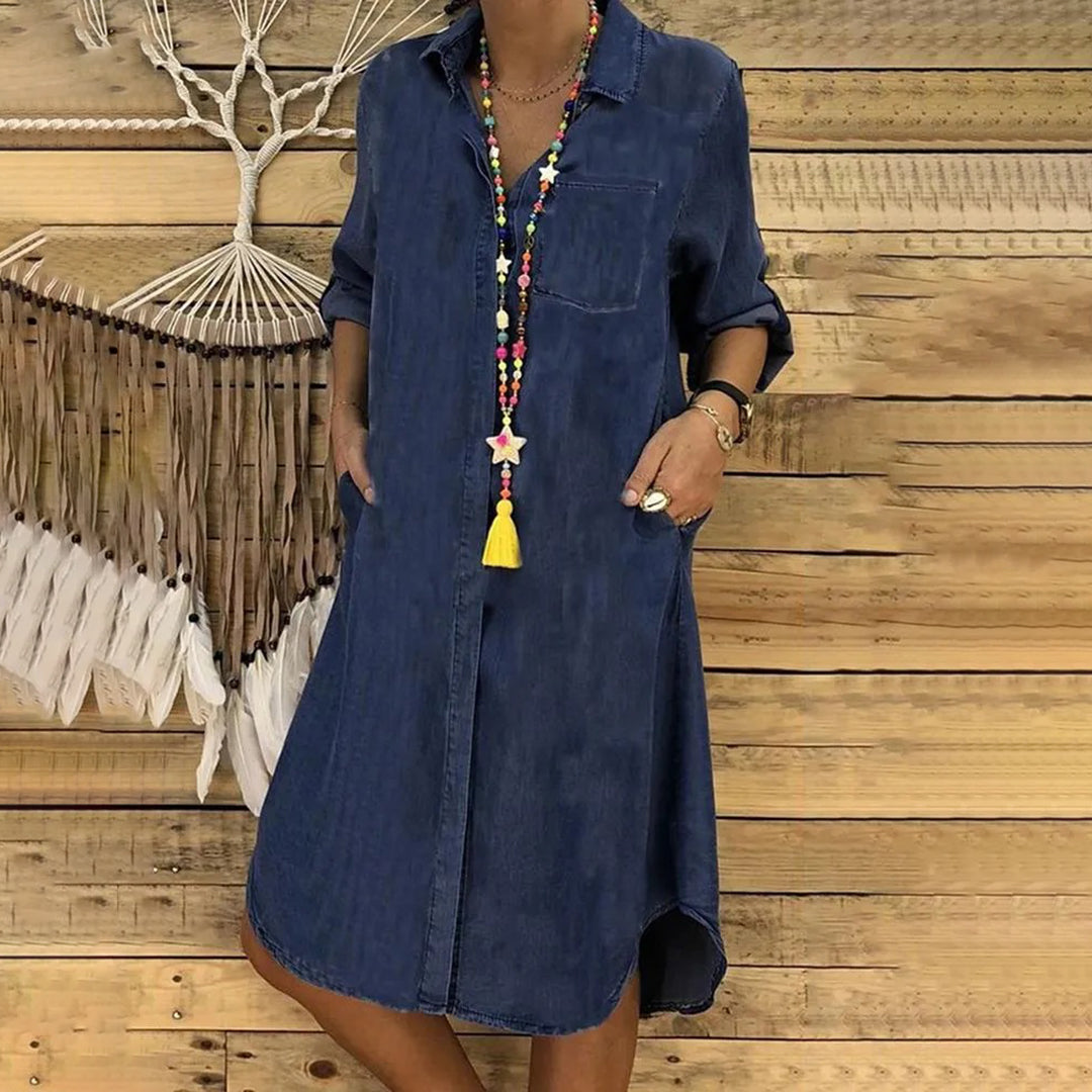 "Stilfuld forårskjole i blå og mørkeblå, elegant snit, ideel til sæsonens skiftende vejr, flaterende og komfortabel."