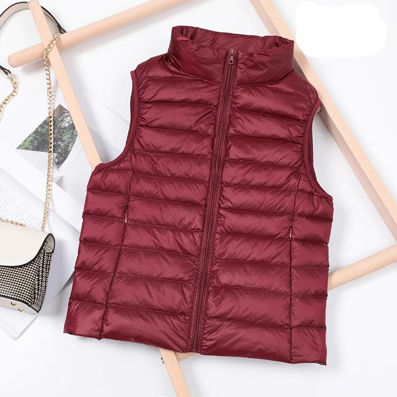 "Stilfuld, letvægts pufferjakke til kvinder; ærmeløs, varmeisolerende, velegnet til efterår og vinter."