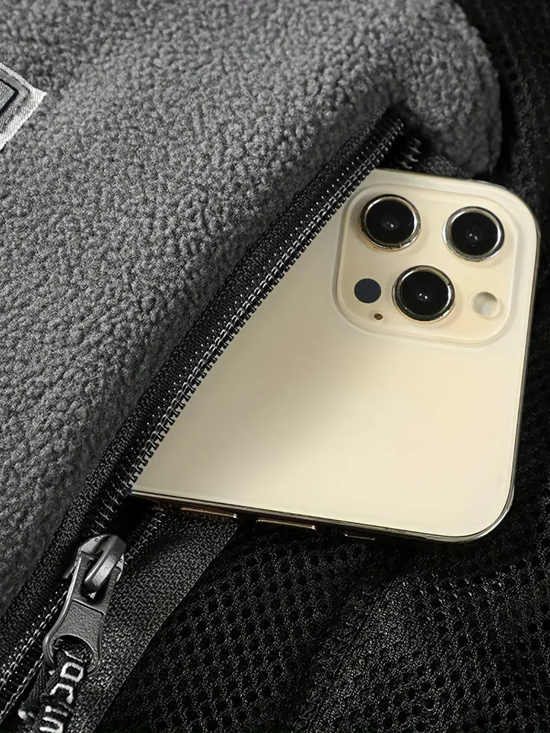 "Termisk fleecejakke i mørkeblå med lynlås, isolerende for og vandafvisende overflade, perfekt til vinterbrug."